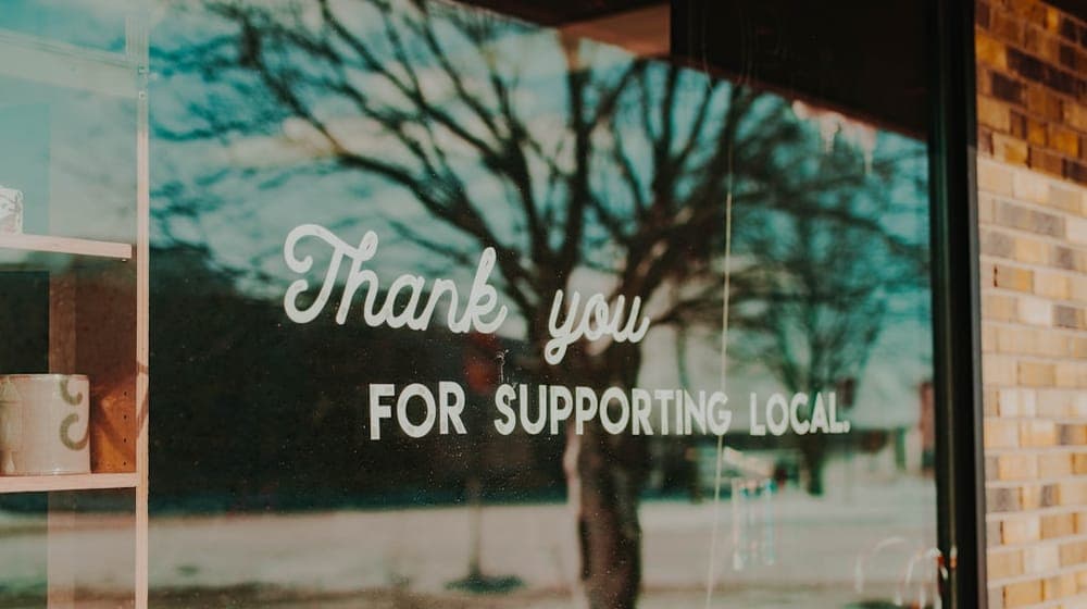 Window sign stating, thank you for supporting local