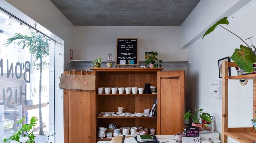 rectangular white wooden table near brown wooden cabinet with ceramic tea set